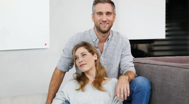 Ein Mann und eine Frau sitzen entspannt auf einem Sofa.