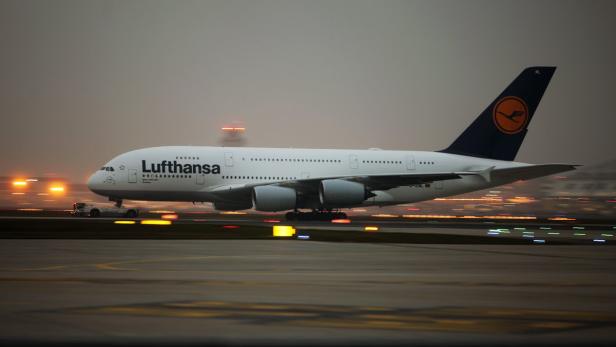 Ein Lufthansa A380 Flugzeug auf einer beleuchteten Startbahn.