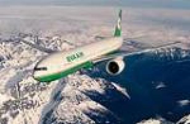 Ein Flugzeug von EVA Air überfliegt eine schneebedeckte Berglandschaft.