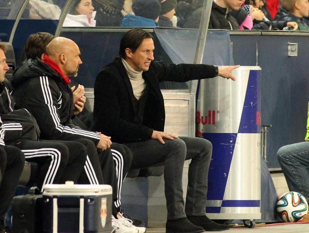 Ein Fußballtrainer gestikuliert von der Bank aus.