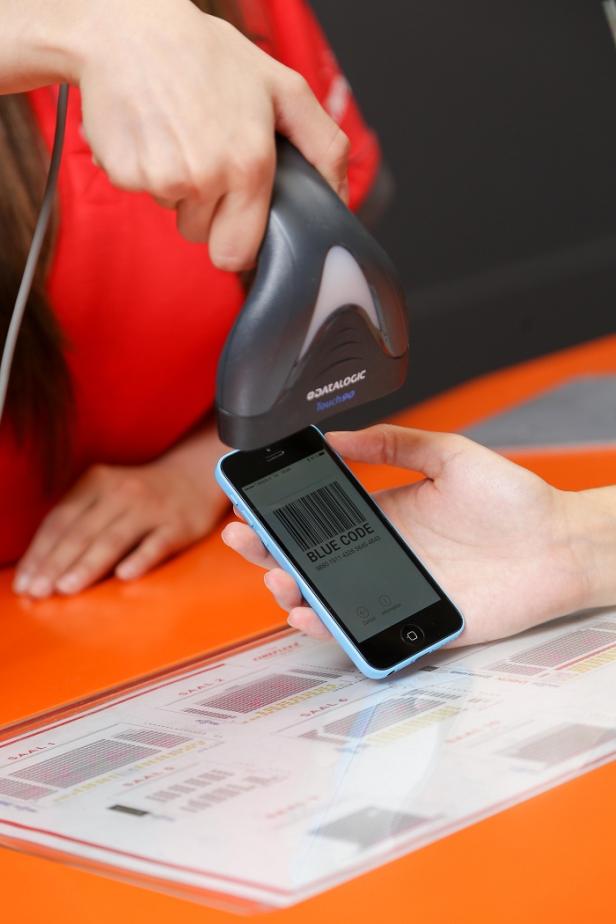 Ein Barcode auf einem Smartphone wird mit einem Scanner erfasst.