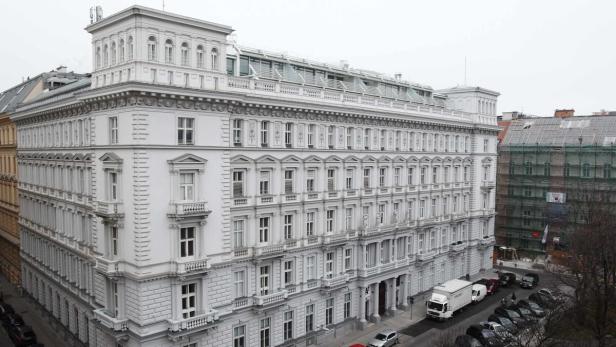 Ein großes, weißes Gebäude mit vielen Fenstern und architektonischen Details in einer Stadt.