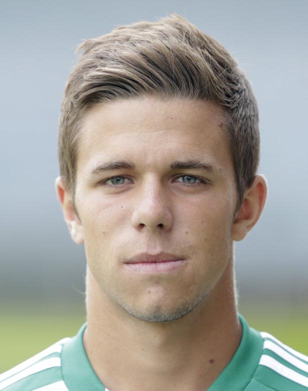 Porträt eines jungen Mannes mit blonden Haaren und einem grün-weiß gestreiften Trikot.