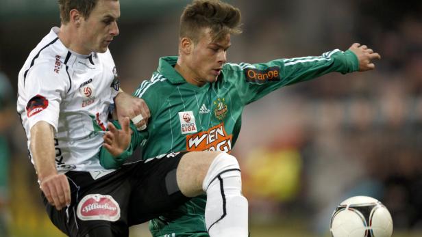 Zwei Fußballspieler kämpfen um den Ball.