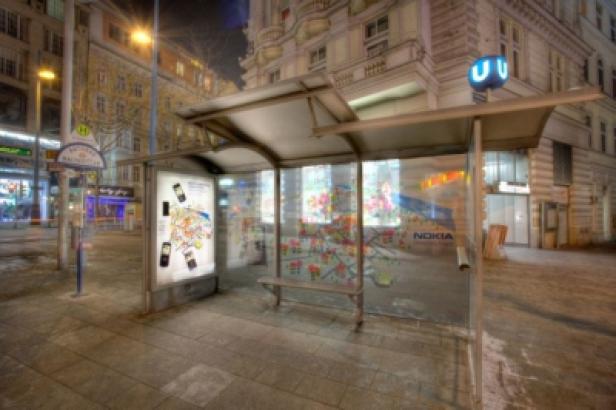 Eine Bushaltestelle in einer städtischen Umgebung bei Nacht.