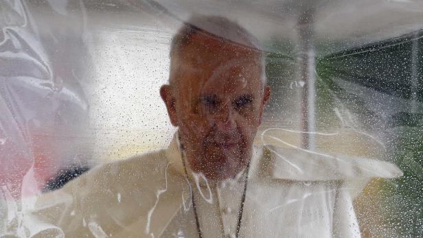 Papst Franziskus hinter einer transparenten Schutzwand.