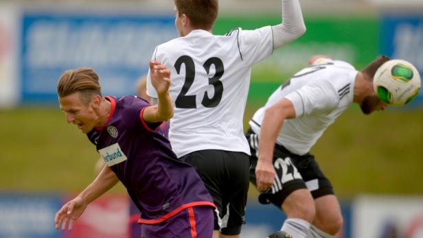 Fußballspieler köpfen während eines Fußballspiels den Ball.