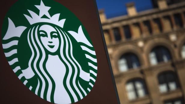 Das grüne und weiße Starbucks-Logo vor einem Gebäude.
