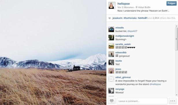 Eine kleine Kirche in einer weiten Landschaft mit schneebedeckten Bergen im Hintergrund.