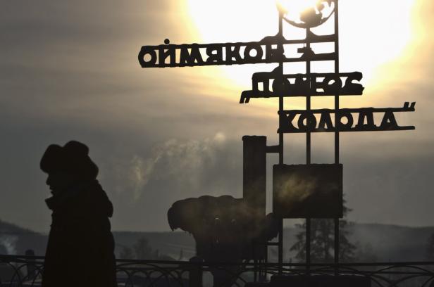 Silhouette einer Person vor einem Schild in Oimjakon, bekannt als einer der kältesten bewohnten Orte der Welt.