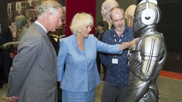 König Charles, Camilla und ein Mann betrachten eine Cyberman-Figur aus „Doctor Who“.