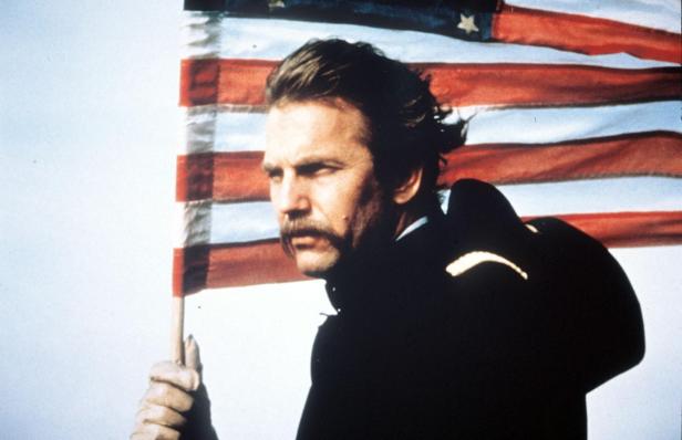 Kevin Costner als Lieutenant John Dunbar vor einer US-Flagge im Film „Der mit dem Wolf tanzt“.