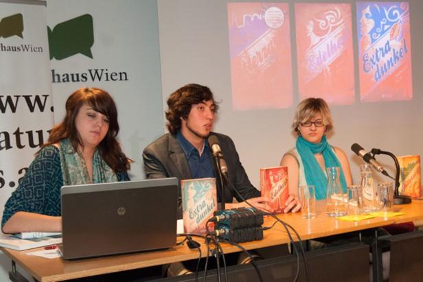 Drei Personen sitzen an einem Tisch bei einer Buchvorstellung von „Extra Dunkel“ und „Edelherb“.