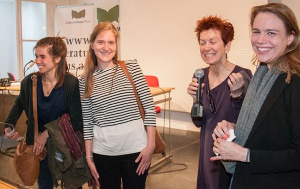 Vier Frauen stehen lächelnd vor einem Banner des Literaturhauses Wien.