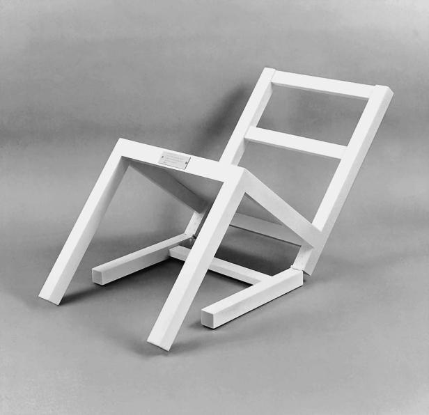 Ein weißer, minimalistischer Stuhl vor einem grauen Hintergrund.