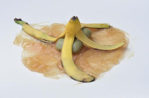 Eine Bananenschale liegt auf einer klebrigen, durchsichtigen Flüssigkeit.