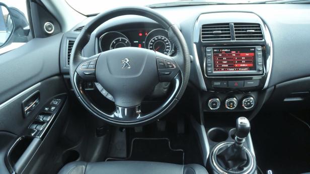 Innenraum eines Peugeot mit Blick auf Armaturenbrett und Lenkrad.