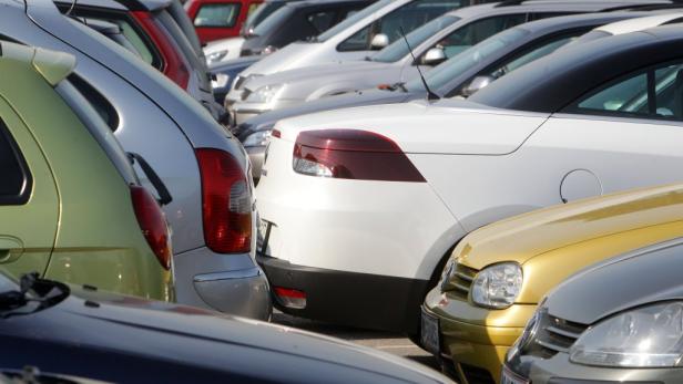 Mehrere Autos stehen Stoßstange an Stoßstange auf einem Parkplatz.