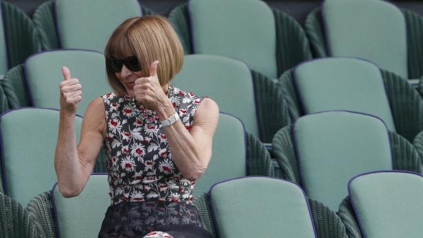 Anna Wintour sitzt auf einem Stuhl und zeigt zwei Daumen nach oben.