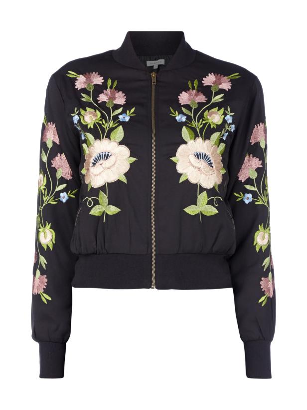 Eine schwarze Bomberjacke mit floralen Stickereien.