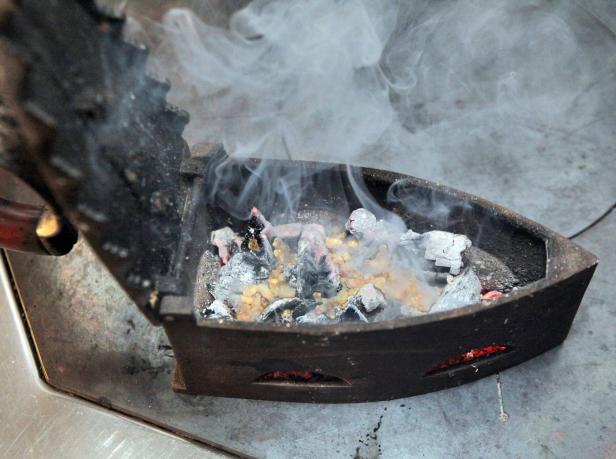 Ein altes Bügeleisen wird zum Räuchern von Harz und Kohle verwendet.