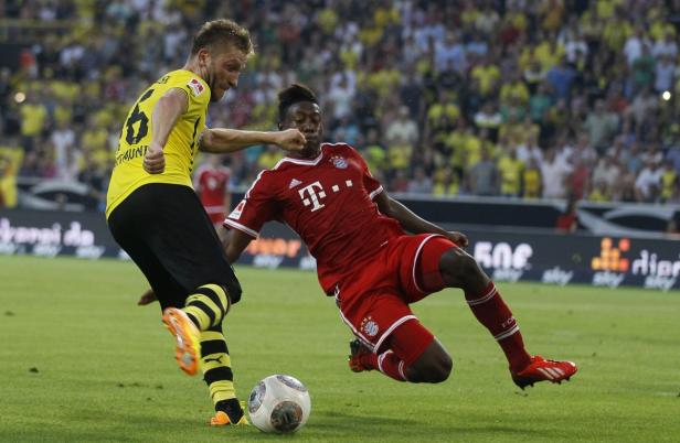 David Alaba (Bayern München) im Zweikampf mit einem Spieler von Borussia Dortmund.