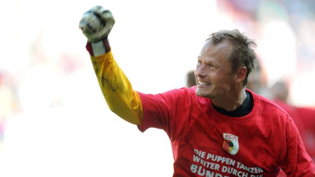 Ein Torwart des FC Augsburg jubelt mit erhobener Faust.