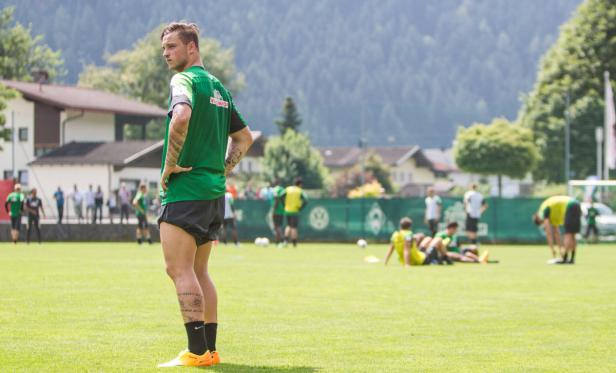 Ein Fußballspieler von Werder Bremen steht auf dem Trainingsplatz.