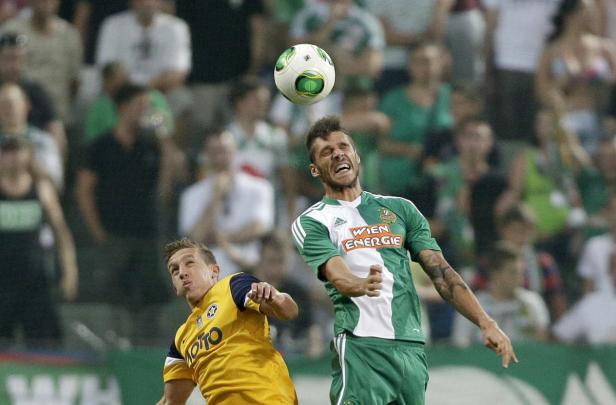 Zwei Fußballspieler kämpfen um den Ball in einem Fußballspiel.