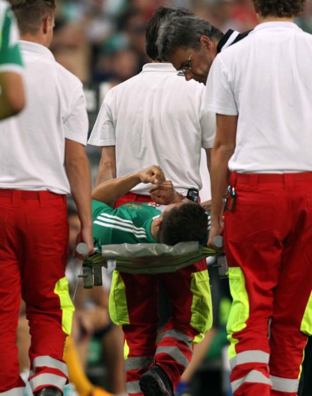 Sanitäter tragen einen verletzten Fußballspieler vom Feld.
