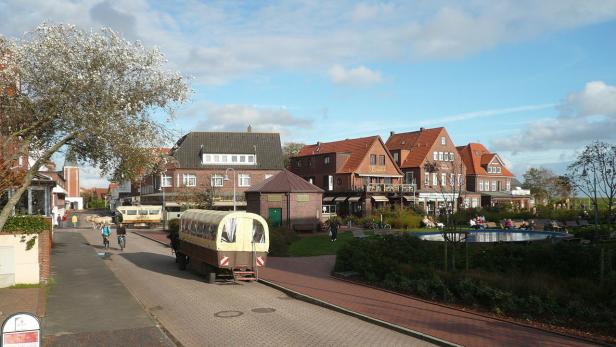 Ein Blick auf eine Straße in einem Dorf mit traditionellen Häusern und einem Planwagen.