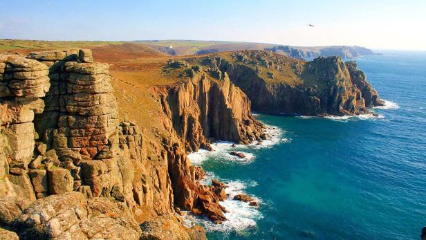 Die zerklüftete Küste von Land's End in Cornwall mit steilen Klippen und blauem Meer.