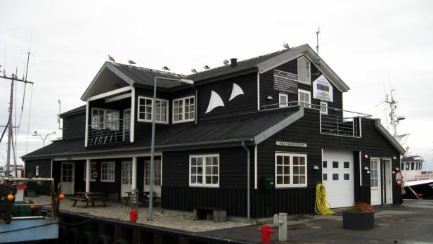 Das Gebäude der Læsø Fiskeriforening mit Möwen auf dem Dach.