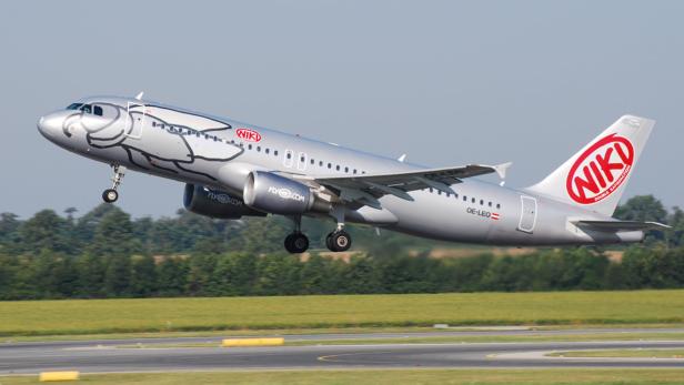 Ein Flugzeug der Fluggesellschaft NIKI startet mit einer Fischzeichnung auf dem Rumpf.