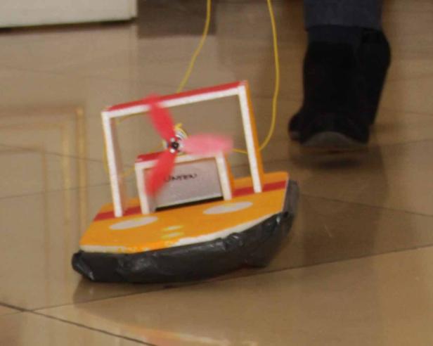 Ein selbstgebautes Luftkissenboot mit einem kleinen Propeller steht auf einem Boden.