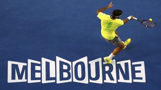 Ein Tennisspieler schlägt den Ball auf einem blauen Platz in Melbourne.