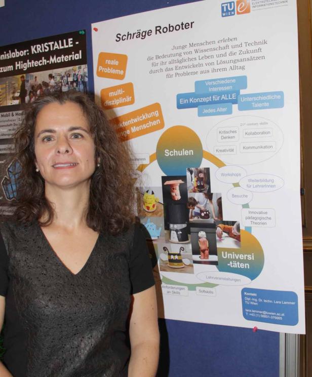 Eine Frau steht vor einem Poster über Robotik und Bildung an der TU Wien.