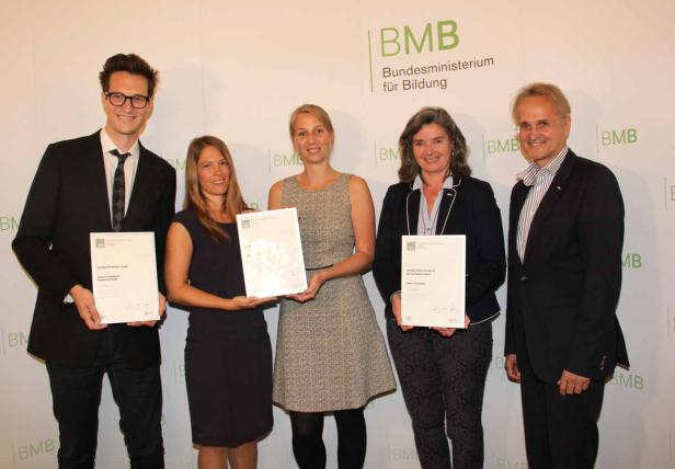 Fünf Personen posieren mit Urkunden vor einem BMB-Hintergrund.