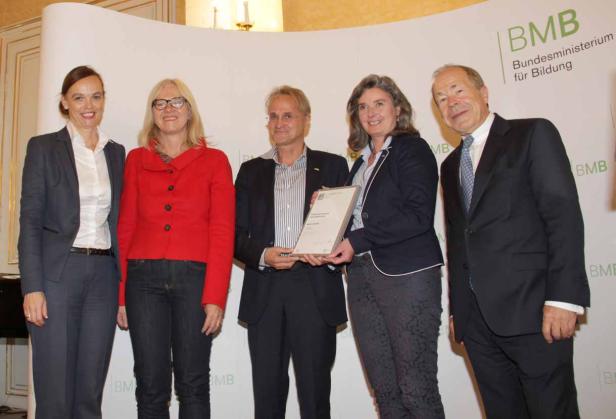 Fünf Personen posieren vor einem Hintergrund des Bundesministeriums für Bildung.