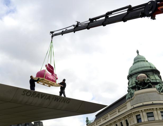 Eine rosa Hasenstatue wird mit einem Kran auf das Dach des Soravia Wing gehoben.