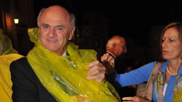 Ein Mann mit gelbem Poncho lächelt in die Kamera.