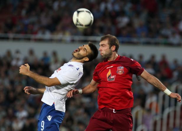 Zwei Fußballspieler kämpfen bei einem Fußballspiel um den Ball.