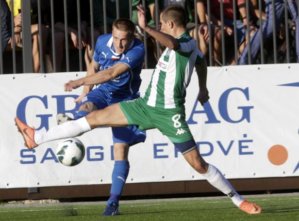 Zwei Fußballspieler kämpfen um den Ball während eines Spiels.