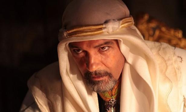 Ein Mann mit Bart und traditioneller arabischer Kopfbedeckung blickt ernst.