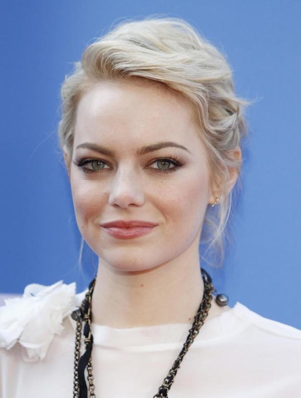 Ein Porträt von Emma Stone mit blonden Haaren und einer Halskette.
