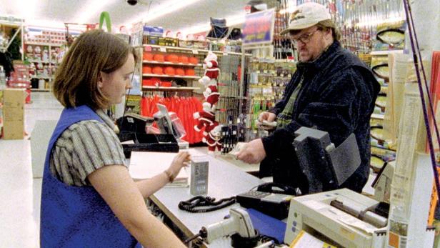 Michael Moore bezahlt an einer Kasse in einem Geschäft.