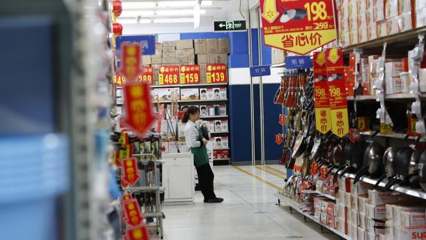 A sales promoter waits for customers at a discount China: Schwächstes Wachstum seit 24 Jahren