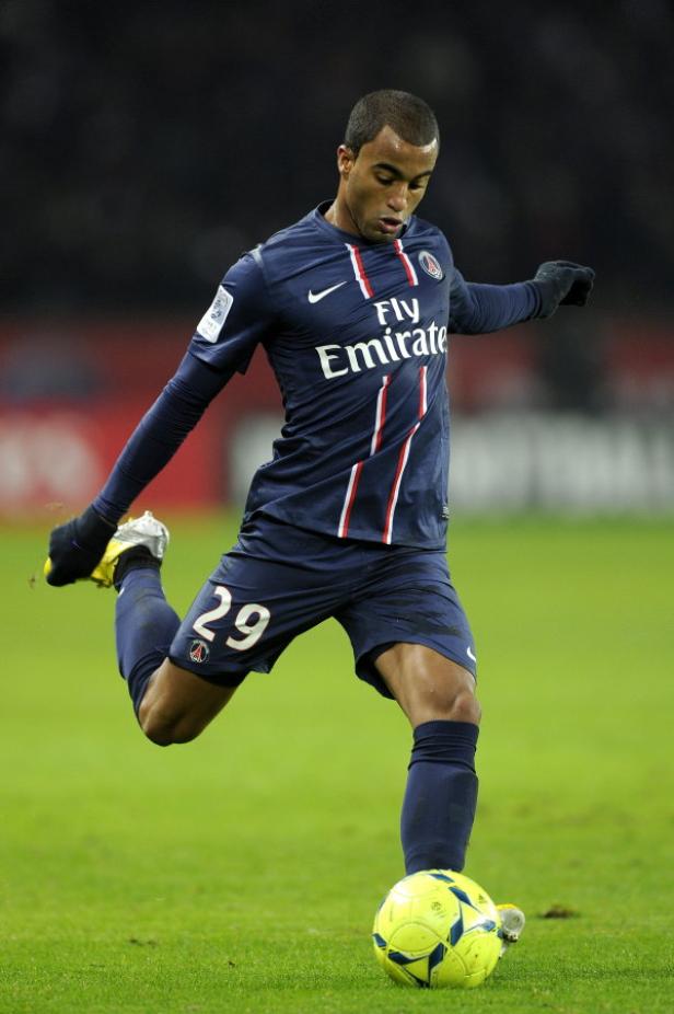 Ein Fußballspieler von Paris Saint-Germain schießt einen gelben Ball.