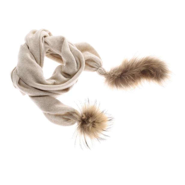 Ein beiger Strickschal mit Fellbommeln an den Enden.