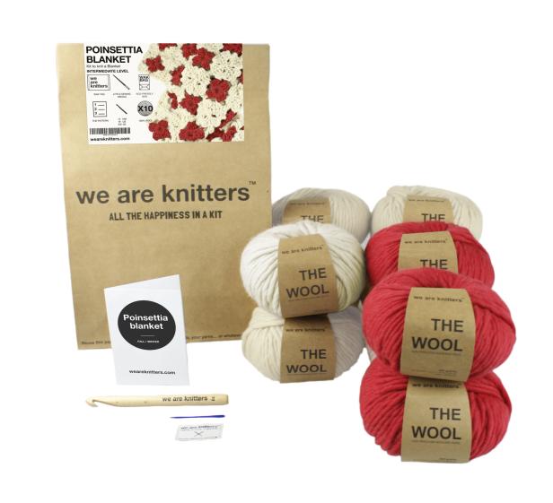 Ein „We are Knitters“-Set zum Häkeln einer „Poinsettia“-Decke mit Wolle in Rot und Beige.